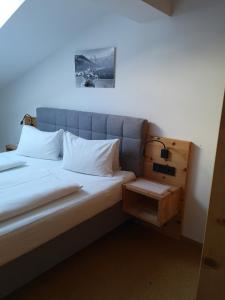 莱奥冈Stockingbauer的一张带白色枕头的床和床头柜