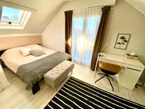 贝尔格莱德Avala Sunset Apartments的一间卧室配有一张床、一张书桌和一个窗户。