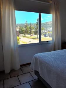 埃斯克尔Hotel Sur Sur Patagónico的一间卧室设有一张床和一个大窗户