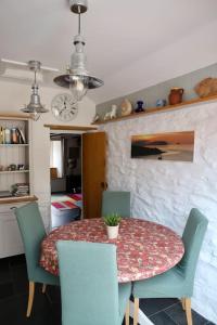 波特斯卡托Cosy thatched Cottage sleeps 6 near Portscatho!的一间带桌子和四把椅子的用餐室