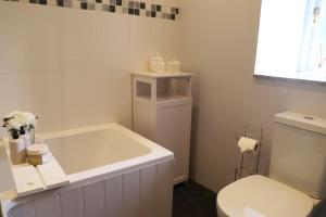 波特斯卡托Cosy thatched Cottage sleeps 6 near Portscatho!的浴室配有白色浴缸和卫生间。