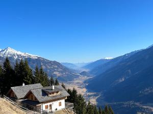 上韦拉赫Bergzauber Obervellach im Mölltal的山边的房屋,俯瞰着山谷