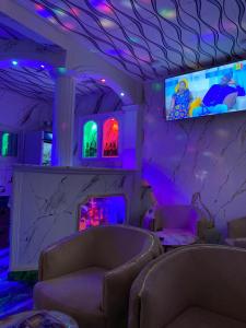 杜阿拉Cave Royale - Chambres-Studios-Apparts meublés - Logpom Hopithal des soeurs ápres Camara Laye的一间设有两张沙发的房间和墙上的一台电视