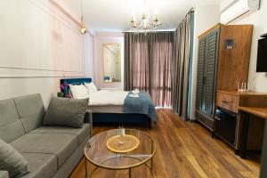 第比利斯Trinity Hotel的客厅配有沙发和1张床