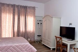 罗马In Terrazza Da Giusy的一间卧室配有一张床和一张书桌及电视