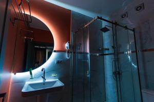 第比利斯Trinity Hotel的浴室配有盥洗盆和带镜子的淋浴