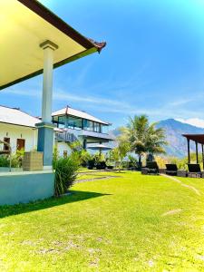 金塔马尼巴图尔火山旅馆的一座带草地大院子的房子