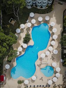 卡拉纳雅达Prinsotel La Pineda的享有带遮阳伞的度假村游泳池的空中景致