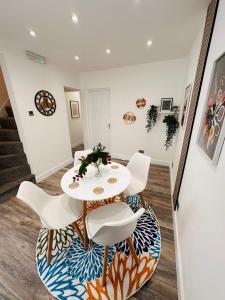 伯明翰R2 - Newly renovated Luxury Private En-Suite Room in Harborne Park Road - Birmingham的一间配备有白色桌椅的用餐室