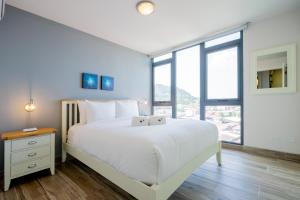 巴拿马城Casco View By Wynwood House的卧室设有白色的床和大窗户