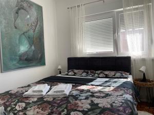 弗尔沙茨Sunny apartment的一间卧室配有一张带毯子和绘画的床