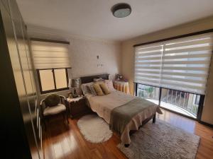 科恰班巴Comodidad y Elegancia的一间卧室设有一张床和一个大窗户