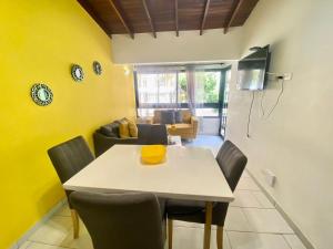 麦德林apartamentos casa Margarita en laureles estadio su hogar en Medellin的用餐室设有黄色的墙壁和桌椅