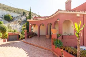 贝纳尔马德纳Villa Romeo, with brand new salt water pool的一座红色的房子,庭院里种有植物