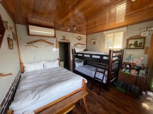 九份九份山海灣民宿 I 近老街 l 海景檜木房的一间卧室配有一张床和一张双层床。
