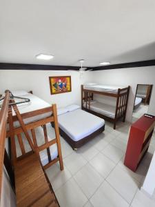 伊利亚贝拉Hospedaria Ilhabela - Flats Sul的客房设有两张双层床和一张桌子。