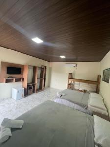 博尼图Bonito Suítes的一间卧室设有两张床和木制天花板