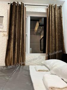 马尼拉Me N’ My Bed Staycation @ SMDC Trees Residences的一间卧室配有床和带窗帘的窗户