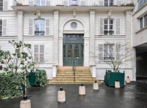 巴黎Lovely Flat Luxembourg Garden的白色的房子,设有绿色的门和楼梯