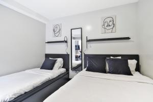 蒙特利尔Parc Avenue Lofts的一间卧室配有两张床和镜子