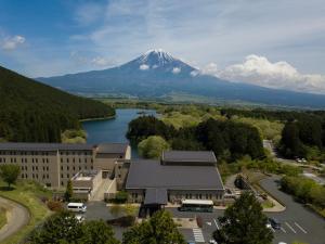 富士宫市Kyukamura Fuji的远处的山,有一座建筑和一座湖泊