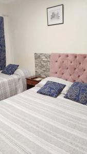 奇廉Hostal Donde Gabriel的一间卧室配有两张带蓝色枕头的床