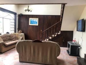 昆卡Casa de campo Country house in Yunguilla, Cuenca, Ecuador的带沙发和楼梯的客厅