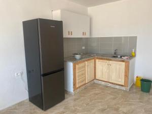 MouamlaBeach houses Lost paradise的厨房配有黑色冰箱和木制橱柜。
