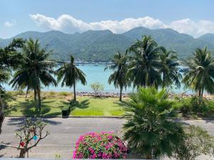 芽庄M Villa Nha Trang的享有棕榈树和鲜花海滩的景色