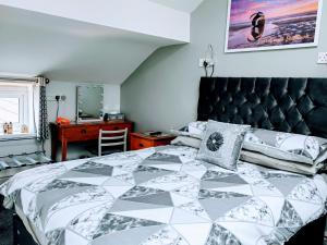 克利夫利斯Seahawk Holiday Apartments的一间卧室配有一张带黑白色棉被的床
