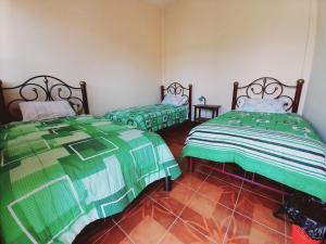 TorotoroHospedaje Matita - Torotoro的配有绿白色毯子的客房内的两张床