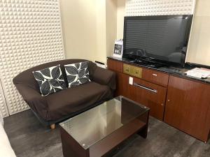 神户Hotel Pareo (Adult Only)的客厅配有椅子和平面电视