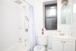 纽约Comfy Guest House in Hell's Kitchen的白色的浴室设有卫生间和水槽。