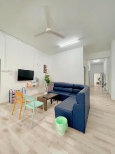 Yong PengColiving room renting Homestay Yong Peng的客厅配有蓝色的沙发和桌子