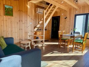 SicasăuAproka - Chalet Mignon Adorable small guest house的客厅设有楼梯和桌椅