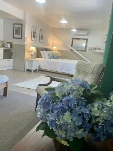 怀蒂昂格Annabells B&B的客厅配有一张床和一束蓝色花瓶