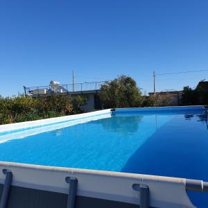 巴尼阿尼奥内Country house pool and sea的一座大型蓝色游泳池,位于一座建筑的顶部