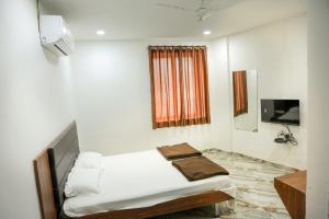 艾哈迈达巴德Hotel Aaram Kalupur的白色的客房配有床和电视