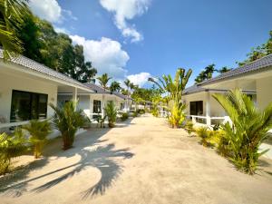 苏梅岛Moorea Boutique Resort Samui的两栋棕榈树建筑之间的路径