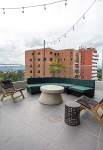 危地马拉Tropical Apartment in the city的大楼内的阳台配有桌椅