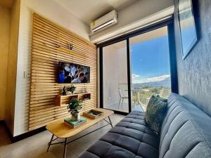 危地马拉Tropical Apartment in the city的带沙发和大窗户的客厅