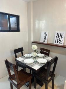 OroquietaAlmar Apartelle的餐桌和椅子,带盘子和鲜花