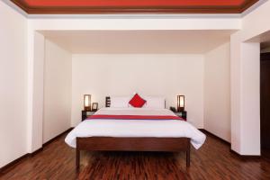 加德满都尚佰林精品酒店的一间卧室配有一张红色枕头的床