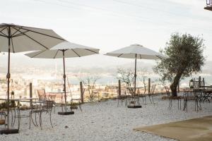 斯培西亚Agriturismo Belvedere 9的海滩上一组桌椅和遮阳伞