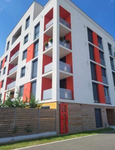阿拉德Sika Sunny Garden Apartment的公寓大楼设有红色和白色的阳台