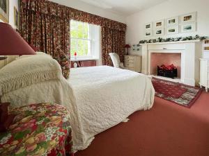 阿普尔克罗斯Applecross Manse的一间卧室配有一张床和一个壁炉