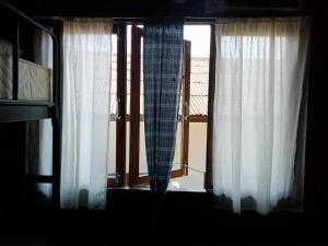 拜县Imchai的窗户配有白色窗帘,享有阳台的景致。