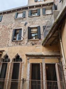 威尼斯My Rialto Palace的一座带窗户和阳台的旧砖砌建筑