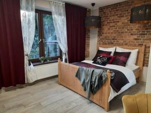 卡托维兹Urocze mieszkanie z parkingiem的一间卧室设有一张床和砖墙