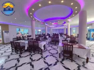 沙姆沙伊赫Club Marine Residence的餐厅设有桌椅和紫色天花板